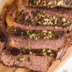 Close up of Sliced Rosemary garlic Slow Cooker Roast Beef served on cutting board