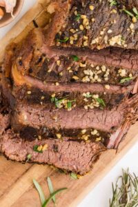 Close up of Sliced Rosemary garlic Slow Cooker Roast Beef served on cutting board