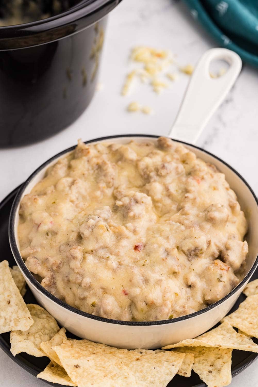 Close up image of Slow Cooker Sausage Cheese Dip served and ready to eat in a bowl with tortilla chips arranged around it