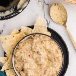 Top view image of Slow Cooker Sausage Cheese Dip served in a bowl with chips