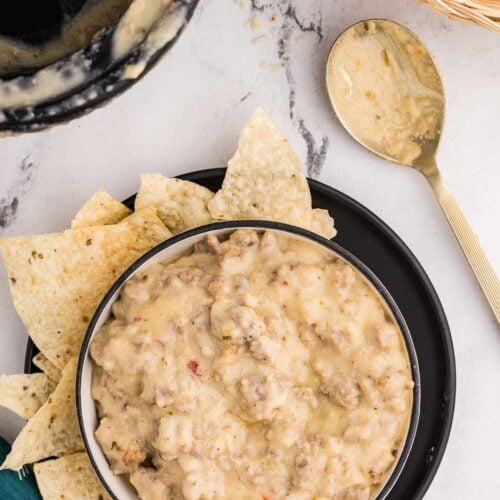 Top view image of Slow Cooker Sausage Cheese Dip served in a bowl with chips