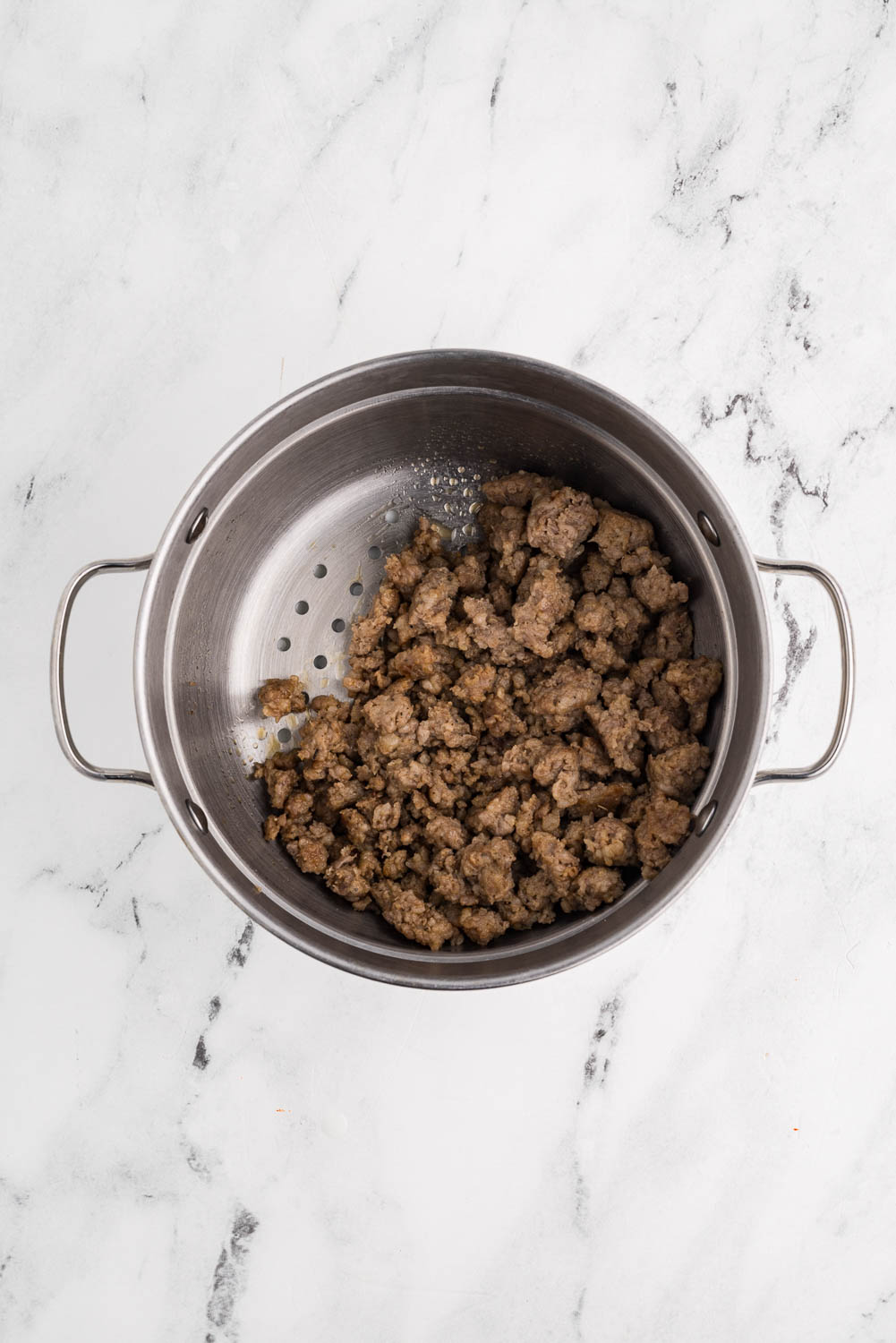 Browned sausage, broken into pieces, placed in a steamer basket