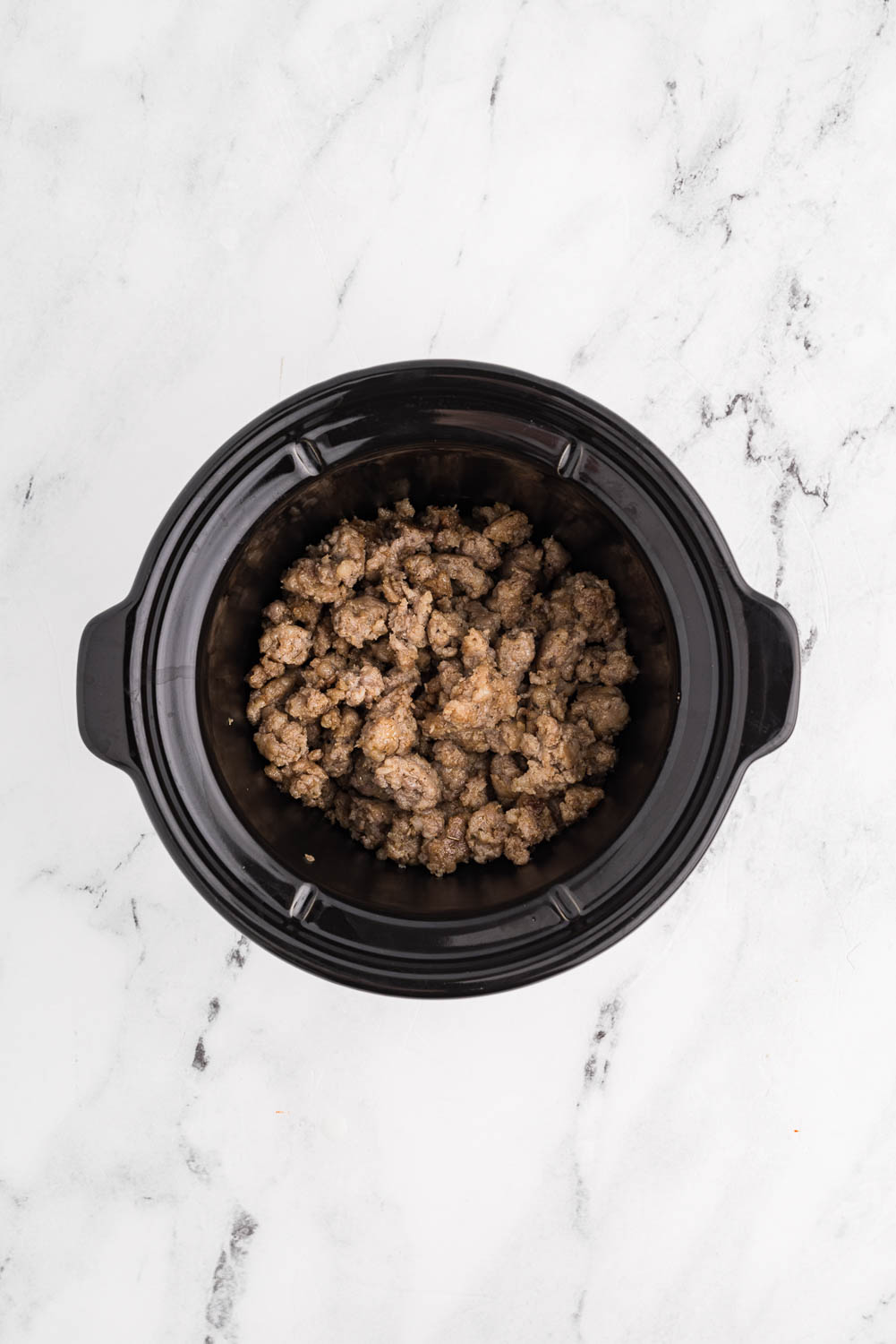 Browned Sausage broken up into pieces in slow cooker