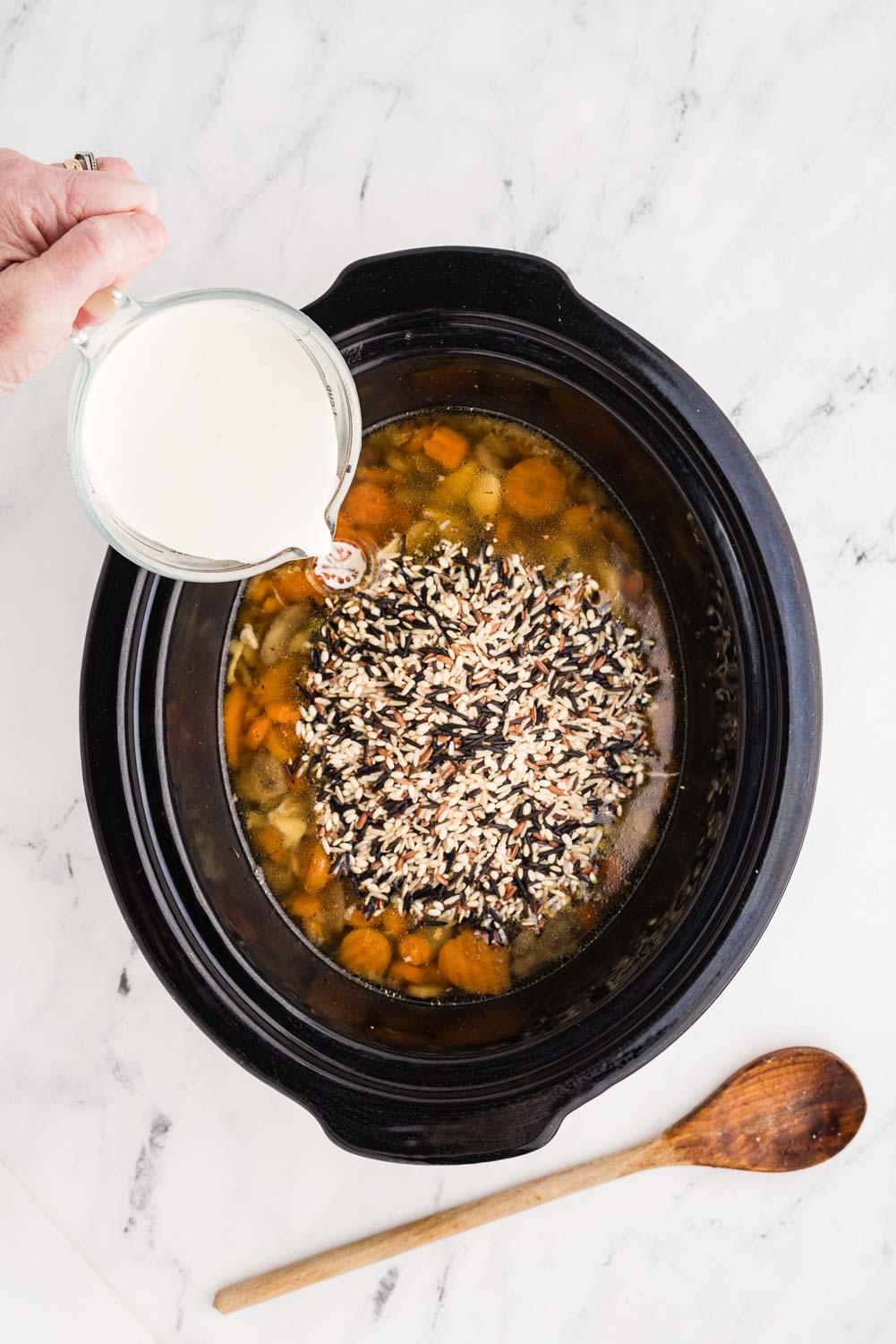 1 1/2 cups chicken broth 1/2 cup Minute Rice Multi-Grain Medley 2 tablespoons whipped cream cheese 1/2 teaspoon dried thyme 1/2 teaspoon garlic powder 1 ounce prosciutto chopped all thrown into slow cooker to make Slow Cooker Chicken and Wild Rice Soup and cream being poured in