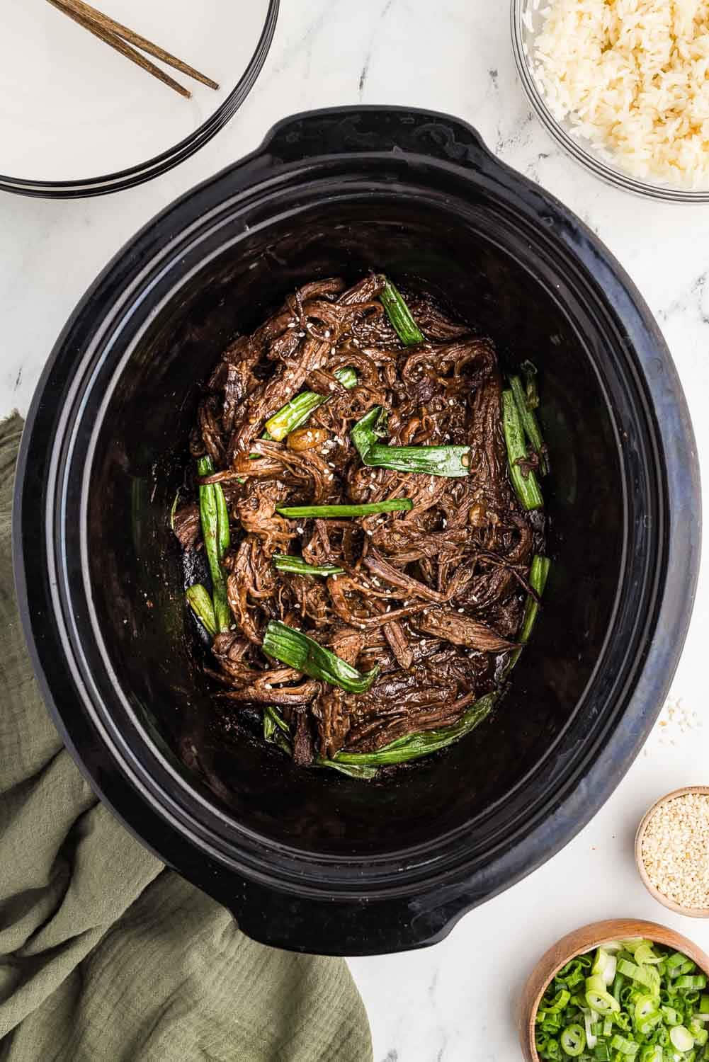 Shredded Mongolian beef topped with freshly sliced green onions, served directly in a slow cooke