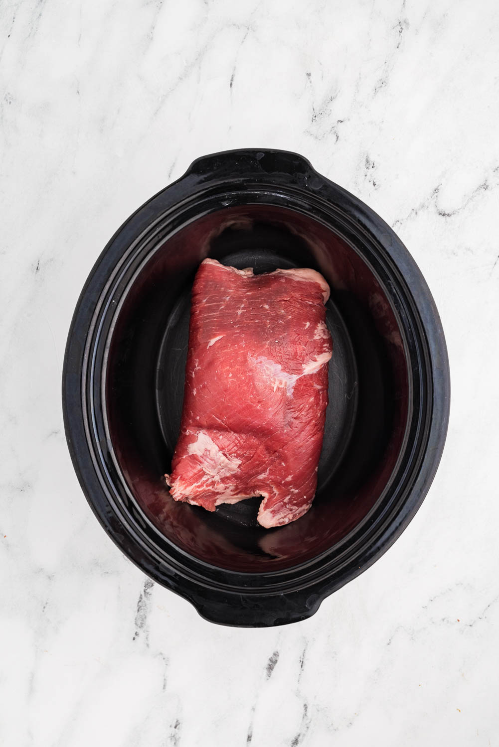 flank steak inside of slow cooker