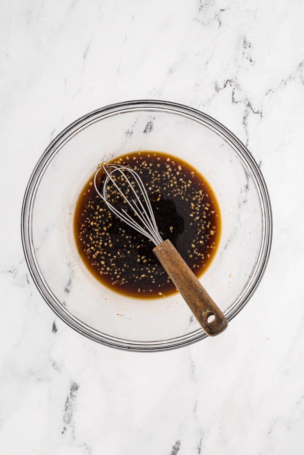 soy sauce, beef broth, sugar, garlic, ginger and Sriracha being Whisked together in bowl