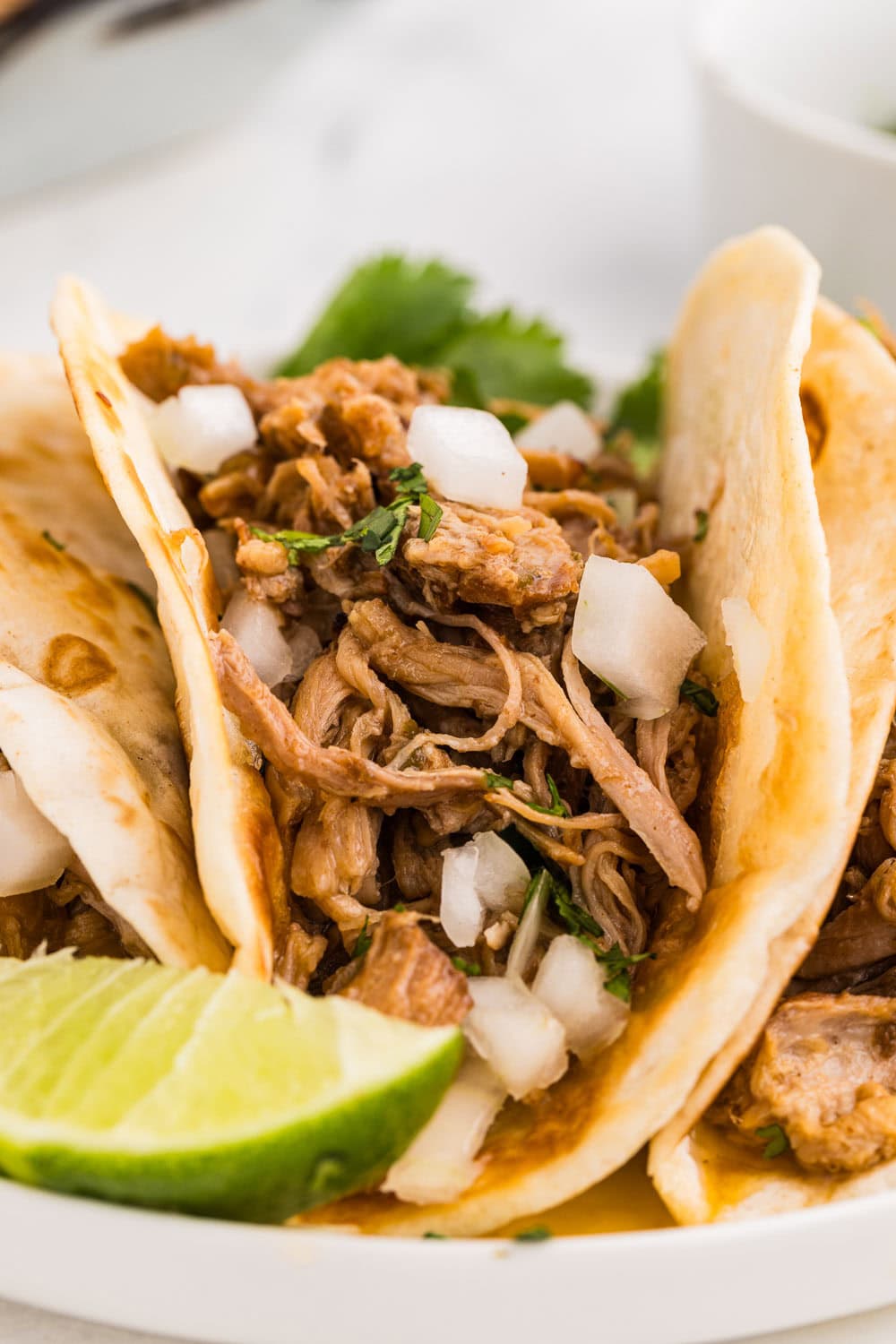 slow cooker carnitas served and garnished with lime
