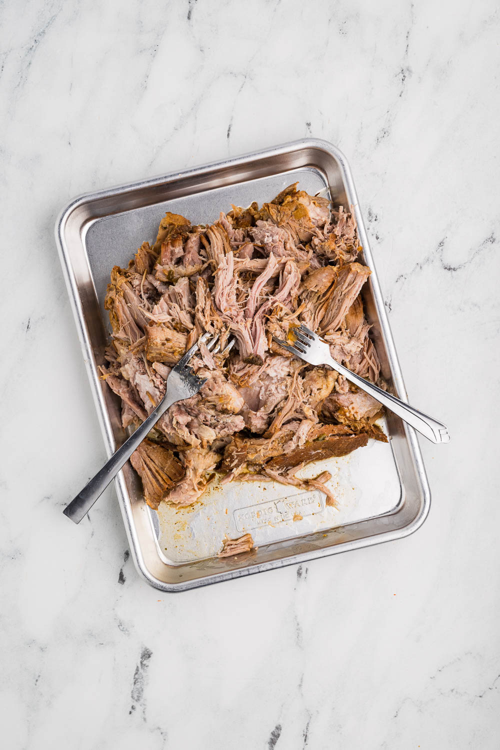 Slow Cooker Carnitas being shredded by 2 forks
