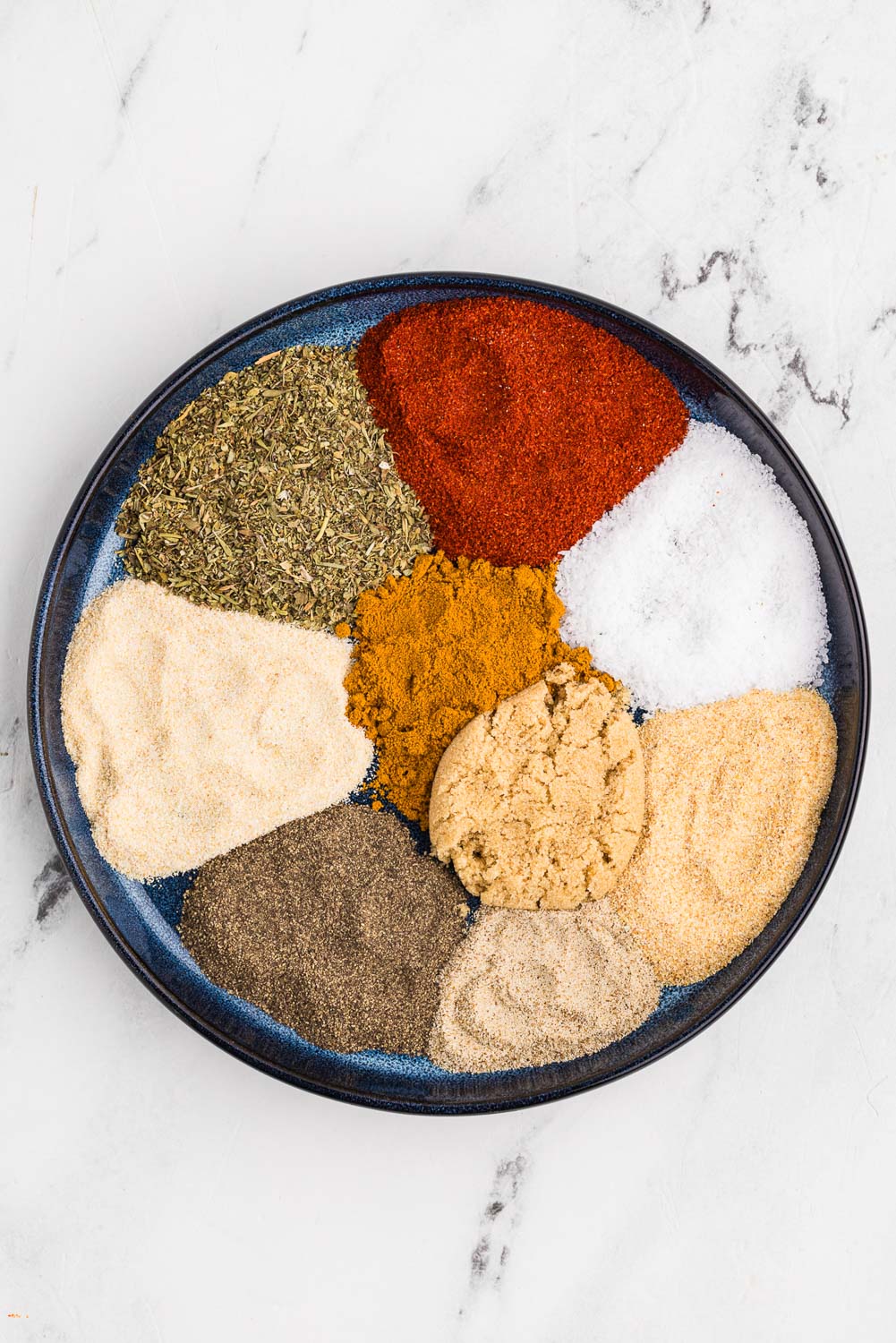 Ingredients neatly laid out and separated in bowl like 2 tablespoons sweet paprika 1 tablespoon Italian seasoning 1 tablespoon kosher salt 1 tablespoon onion powder 1 tablespoon garlic powder 1 tablespoon brown sugar 2 teaspoons turmeric 2 teaspoons black pepper 1 teaspoon celery salt