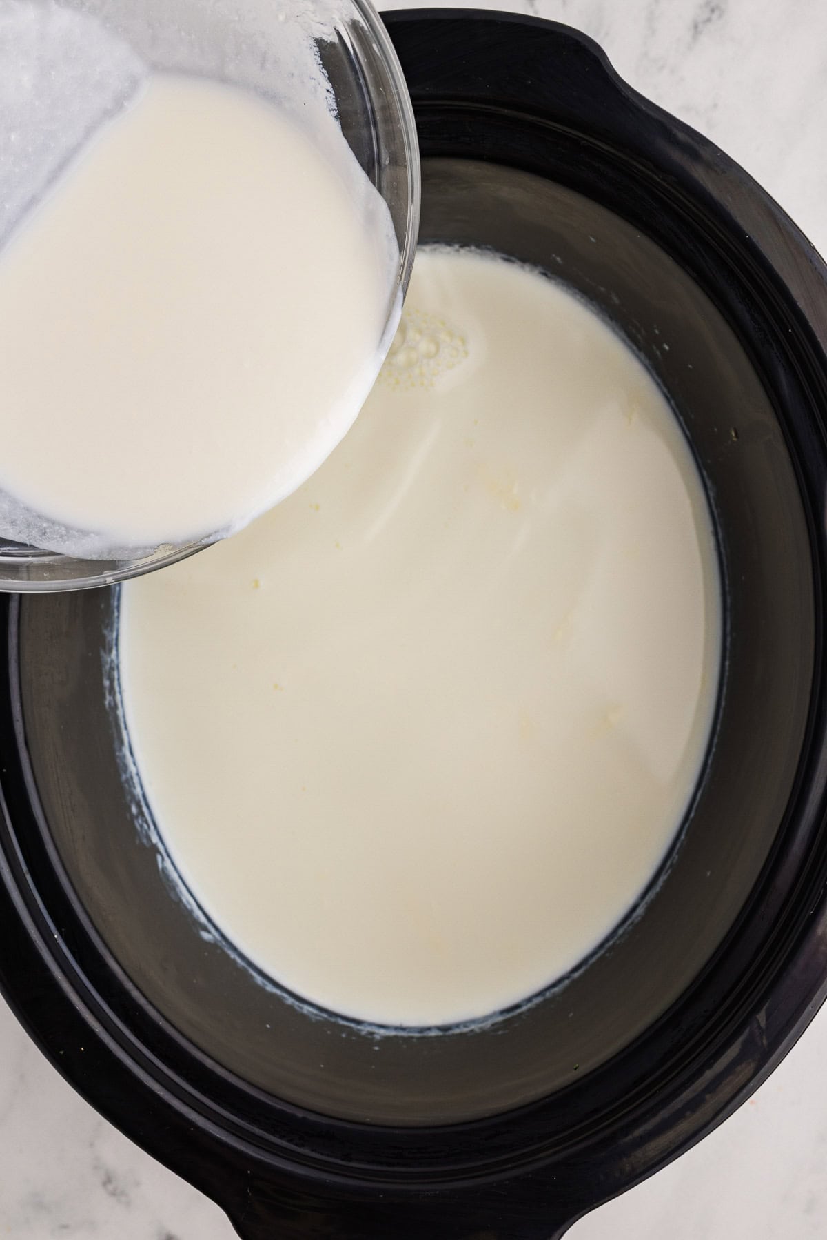 Homemade Yogurt in slow cooker being poured into slow cooker