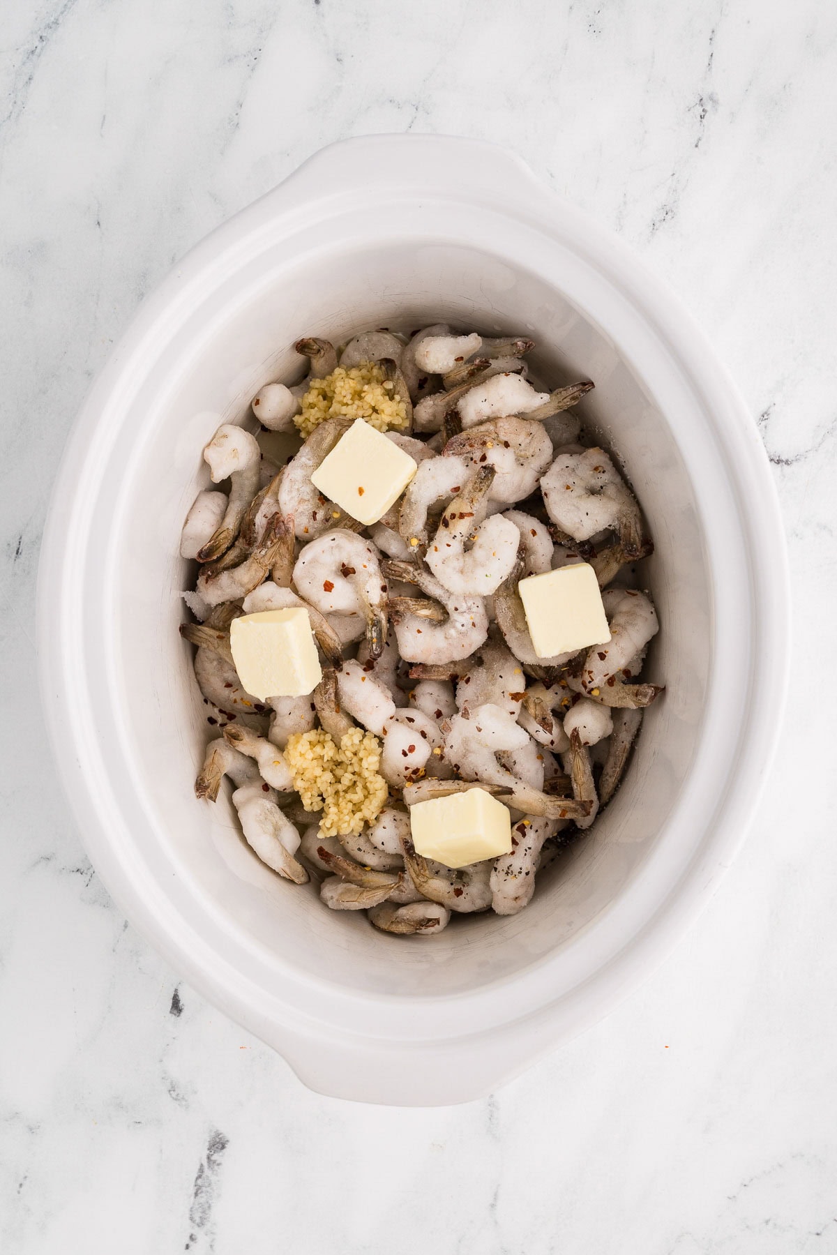 Shrimp, butter, garlic, and seasoning in slow cooker