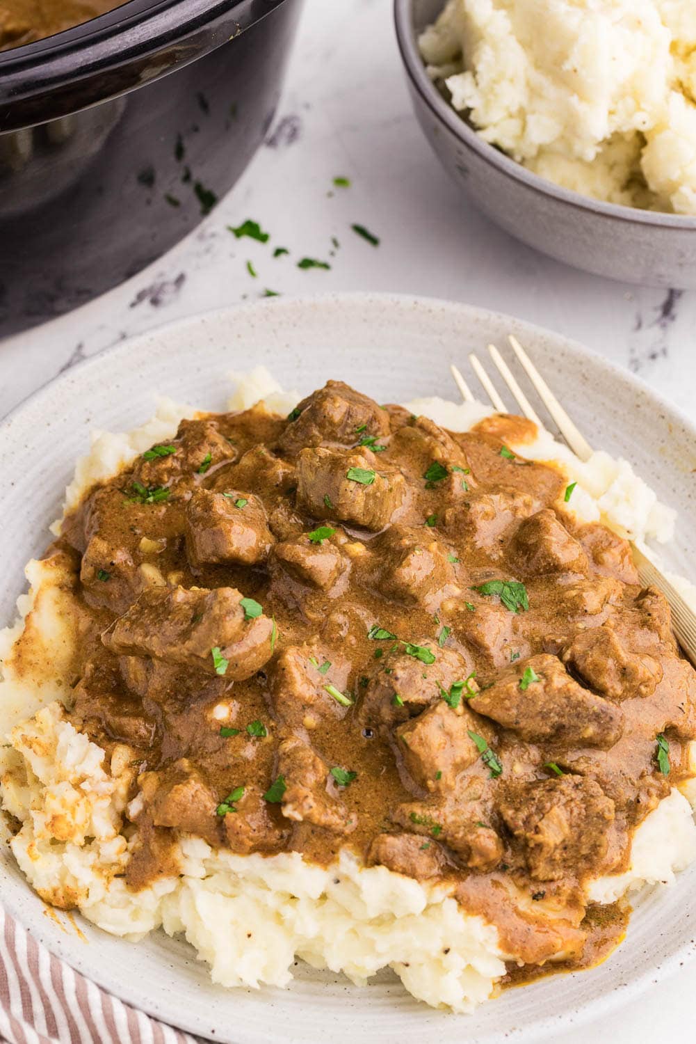 Tender Slow Cooker Steak Bites served and garnished on plate