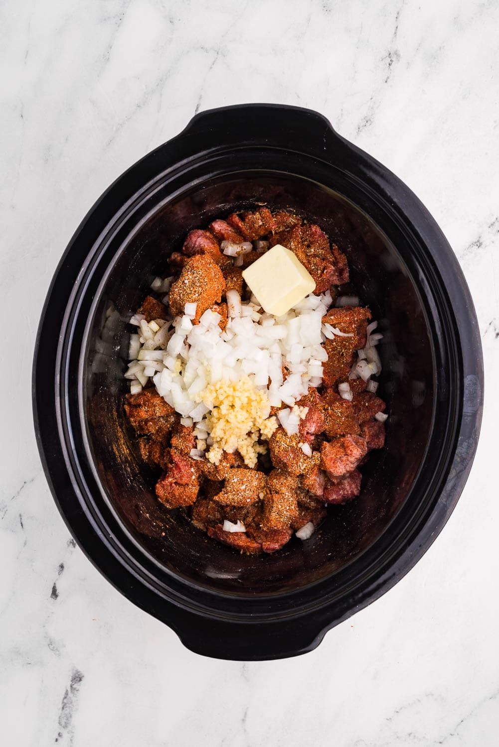 All ingredients 2 pound beef or bison stew meat 2 teaspoons flour (can be gluten-free) 2 tablespoons pot roast seasoning or steak seasoning (homemade or store bought) 1 small sweet onion, chopped 1 tablespoon jarred minced garlic 2 tablespoons butter ½ cup beef broth in slow cooker