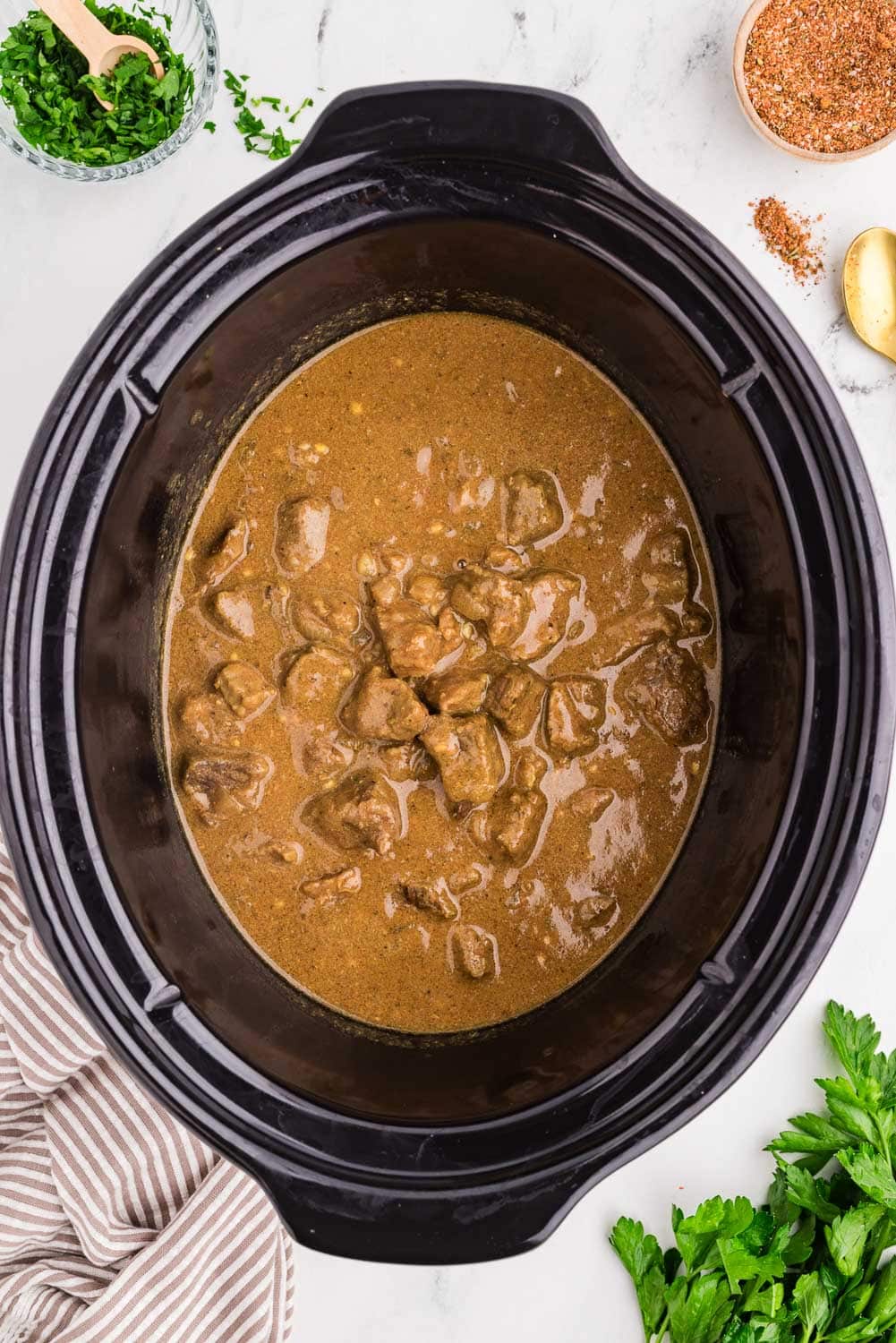Tender Slow Cooker Steak Bites in process of cooking in slow cooker