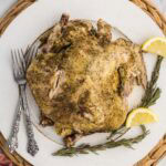 Whole chicken served on plate and garnished