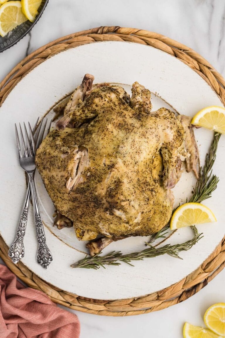 Whole chicken served on plate and garnished