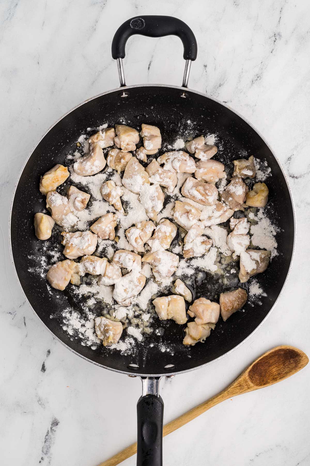 Frying pan with chicken and flour