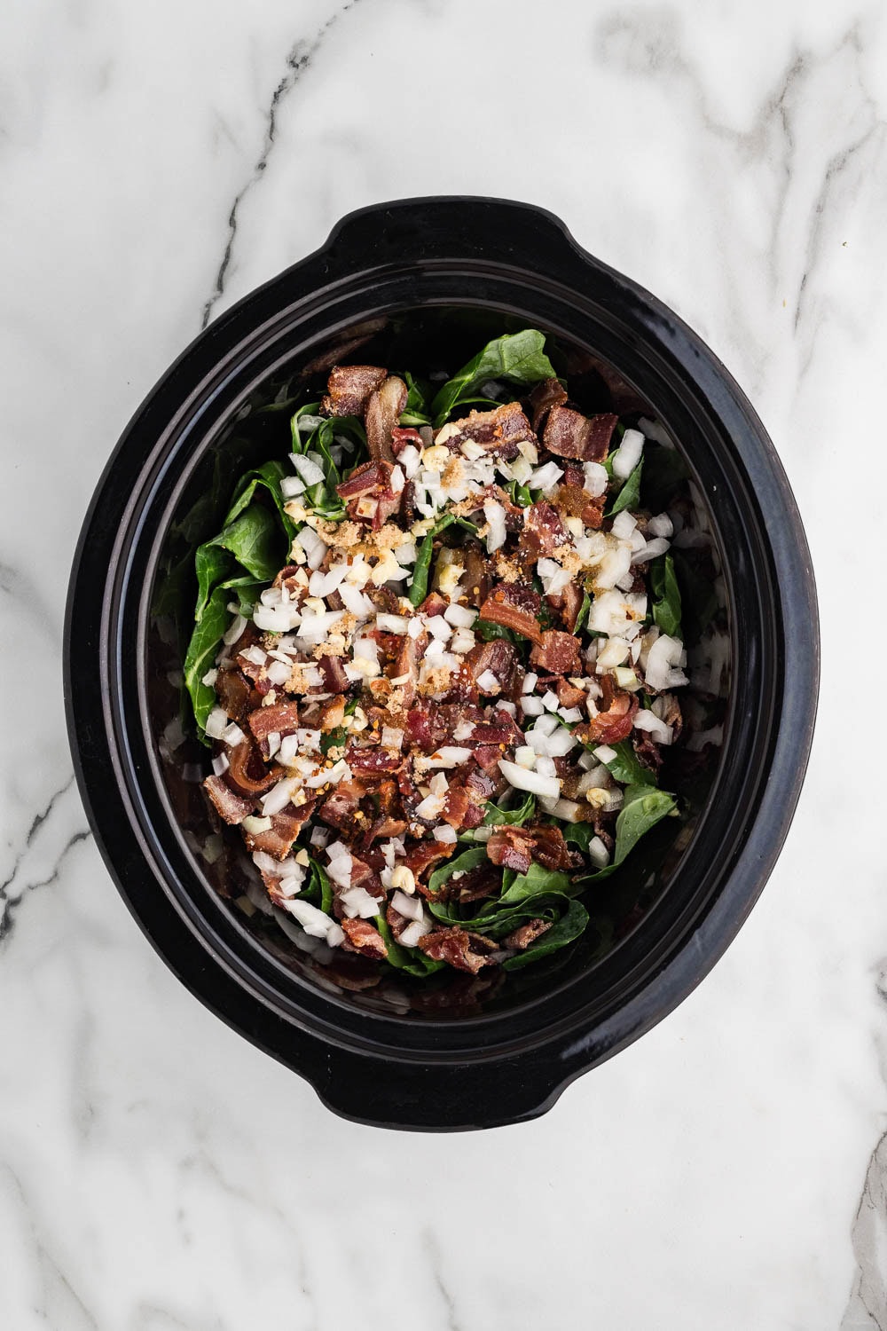Loosely roll up the greens and then slice into thick ribbons in slow cooker