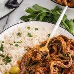 Served Easy Slow Cooker Ropa Vieja served with olives rice and garnished