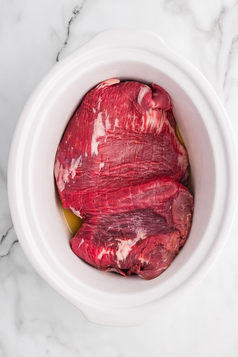 A large piece of meat in a white bowl