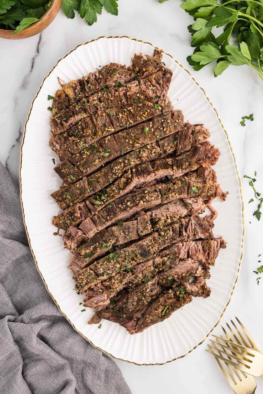 Sliced flank steak on a white plate