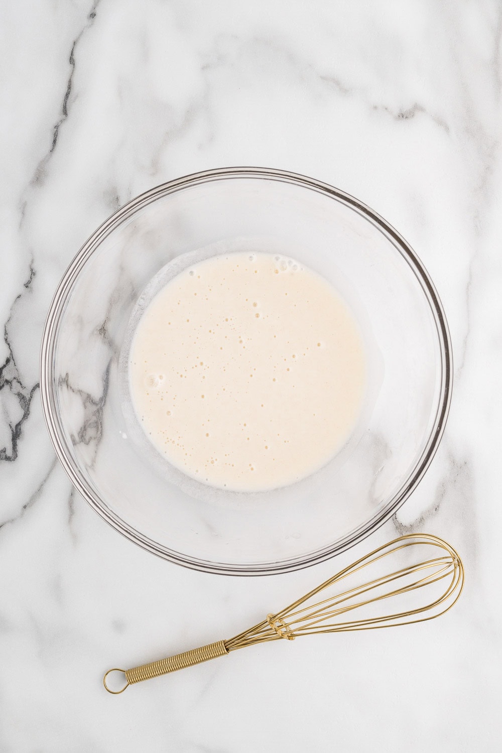 Sauce in glass bowl and whisk