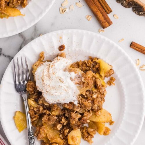 Apple crisp with cinnamon and apples on a white plate