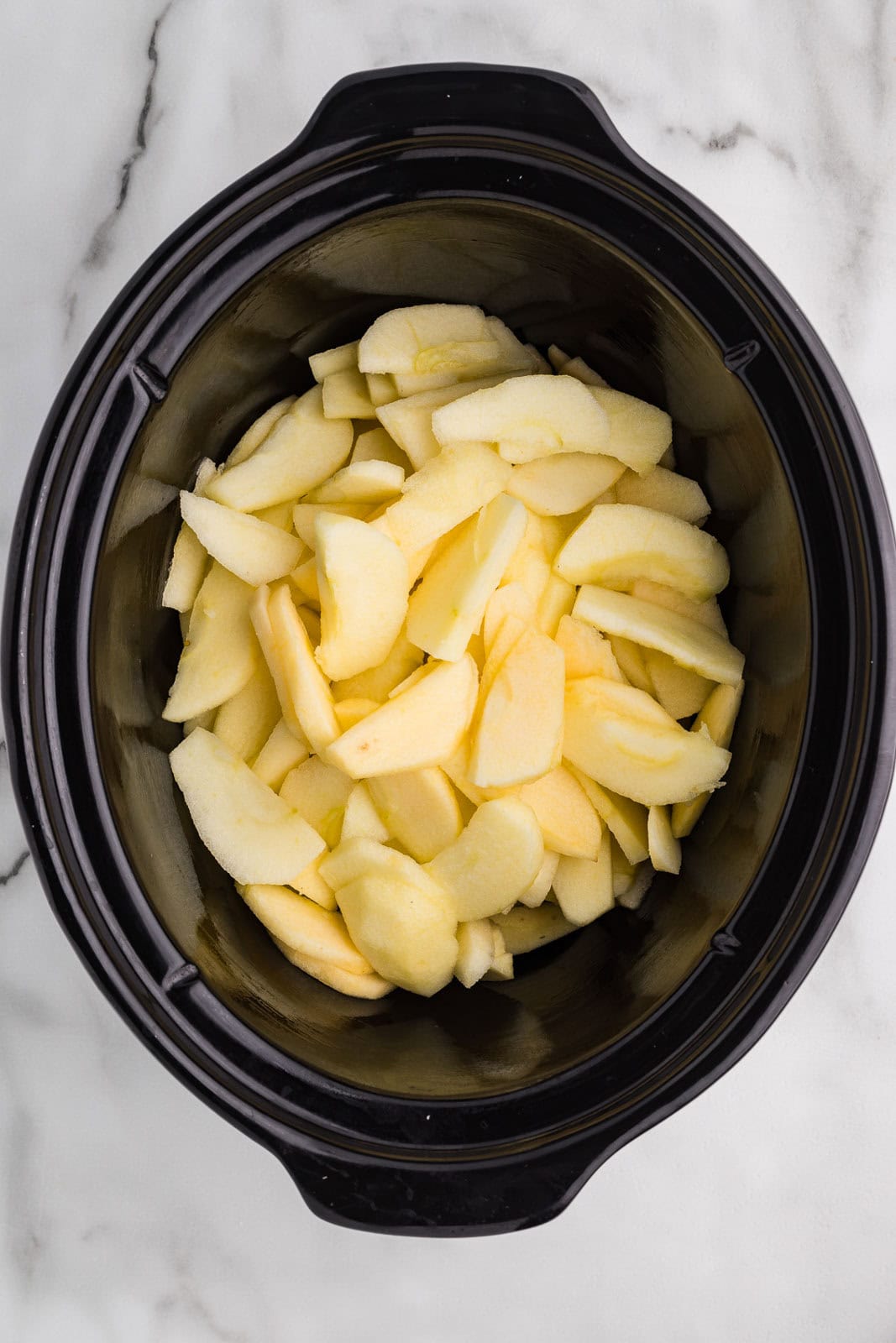 sliced apples in black slow cooker
