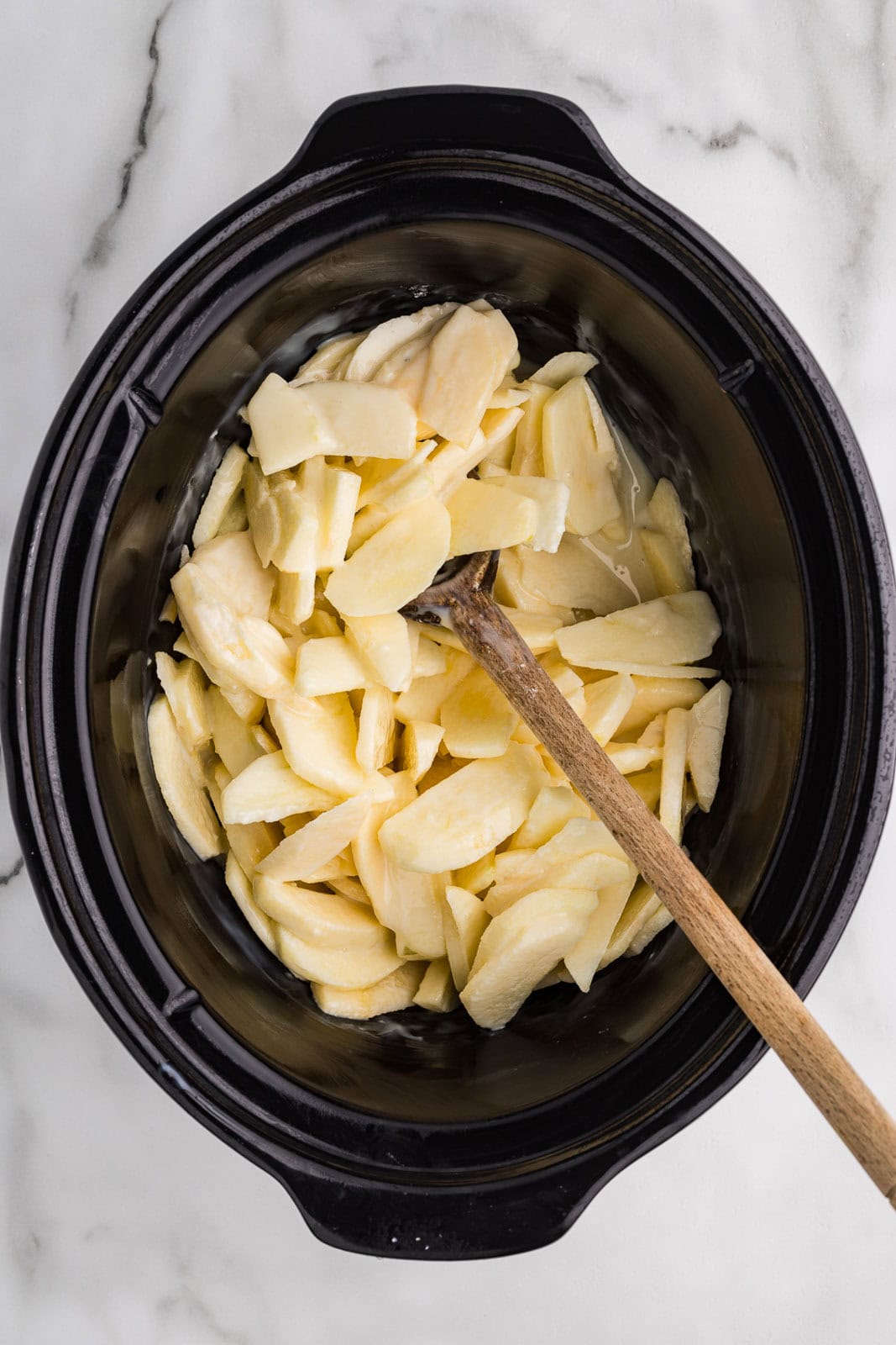 sliced apples in a black slow cooker