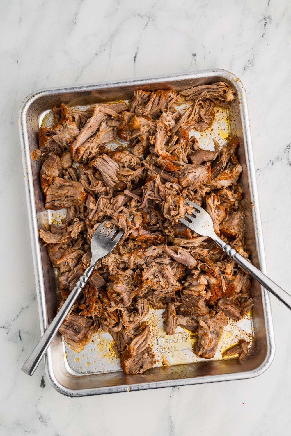 sheet pan with shredded pork with 2 silver forks