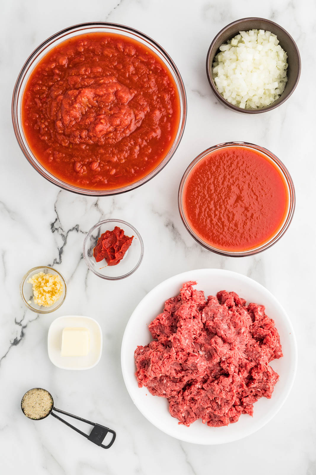 spaghetti sauce ingredients to include tomato sauce, onions, tomatoes, tomato paste, garlic, hamburger, and grated parmesan cheese
