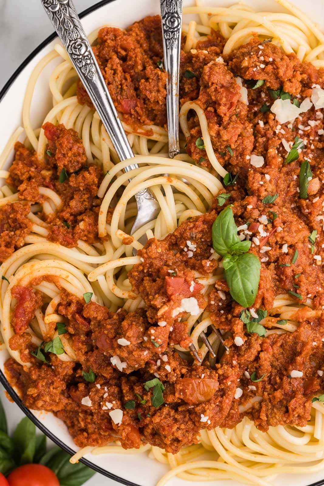spaghetti sauce twisted with pasta with two forks on white plate