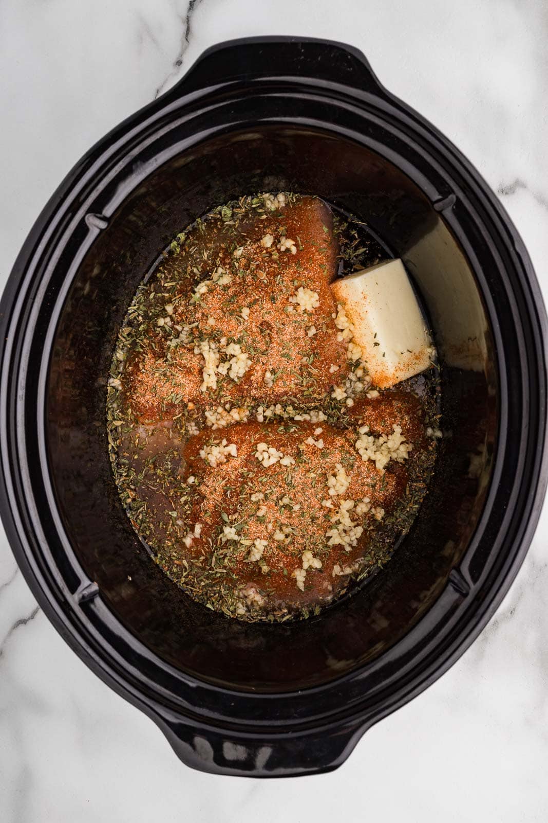 overhead view of black slow cooker with all ingredients