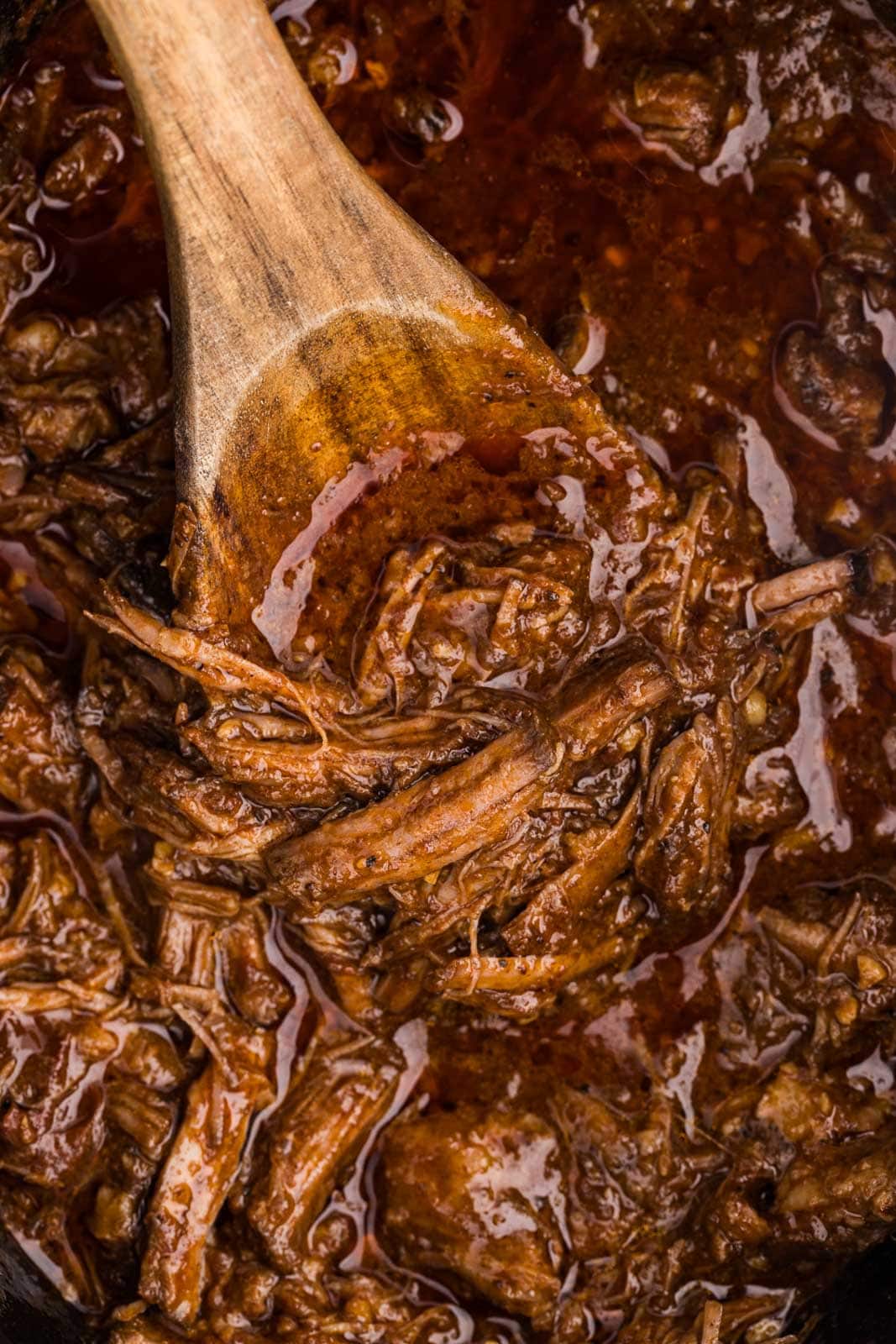 closeup of slow cooked beef with wooden spoon