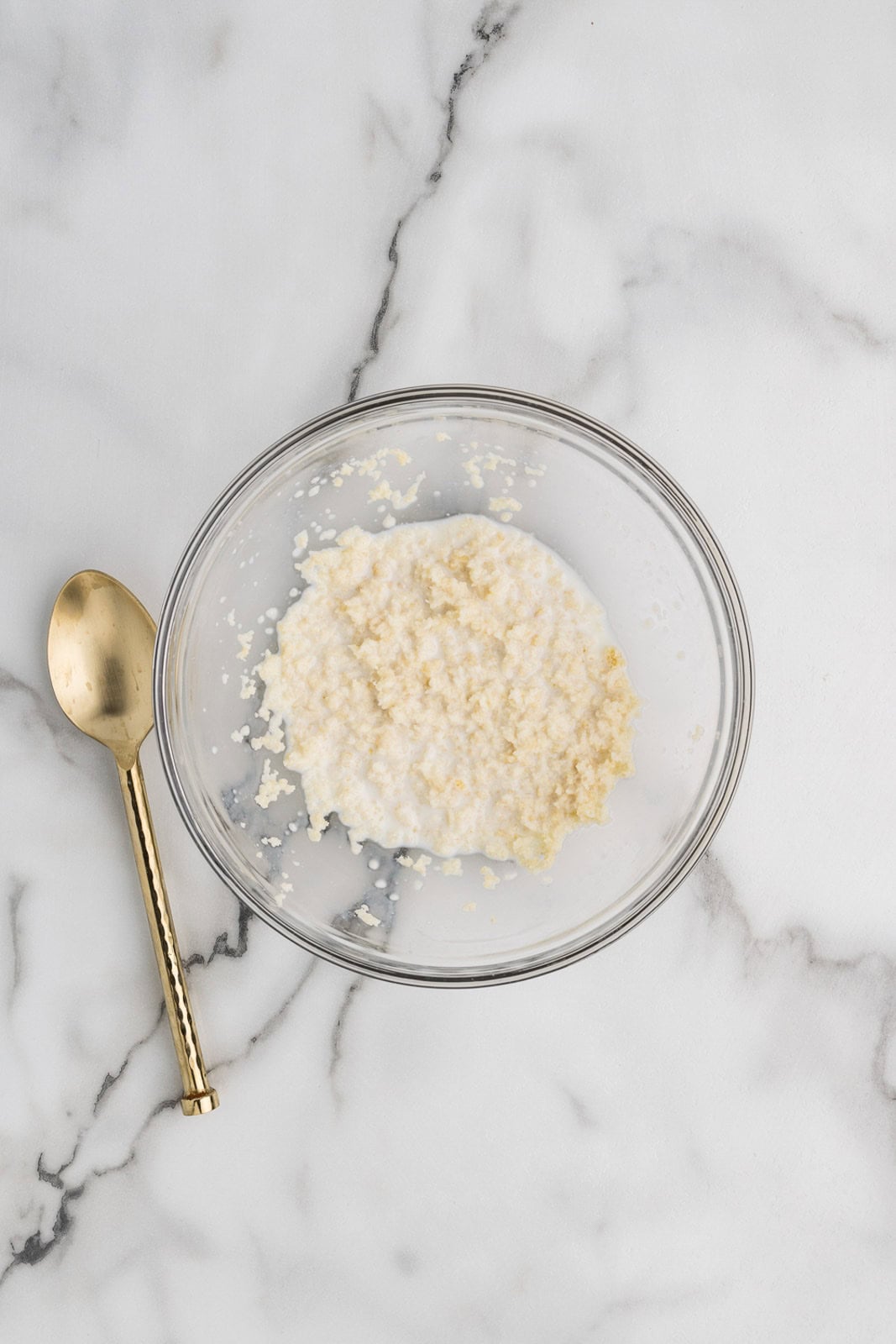 glass bowl with Panko breadcrumbs with milk, spoon on the side