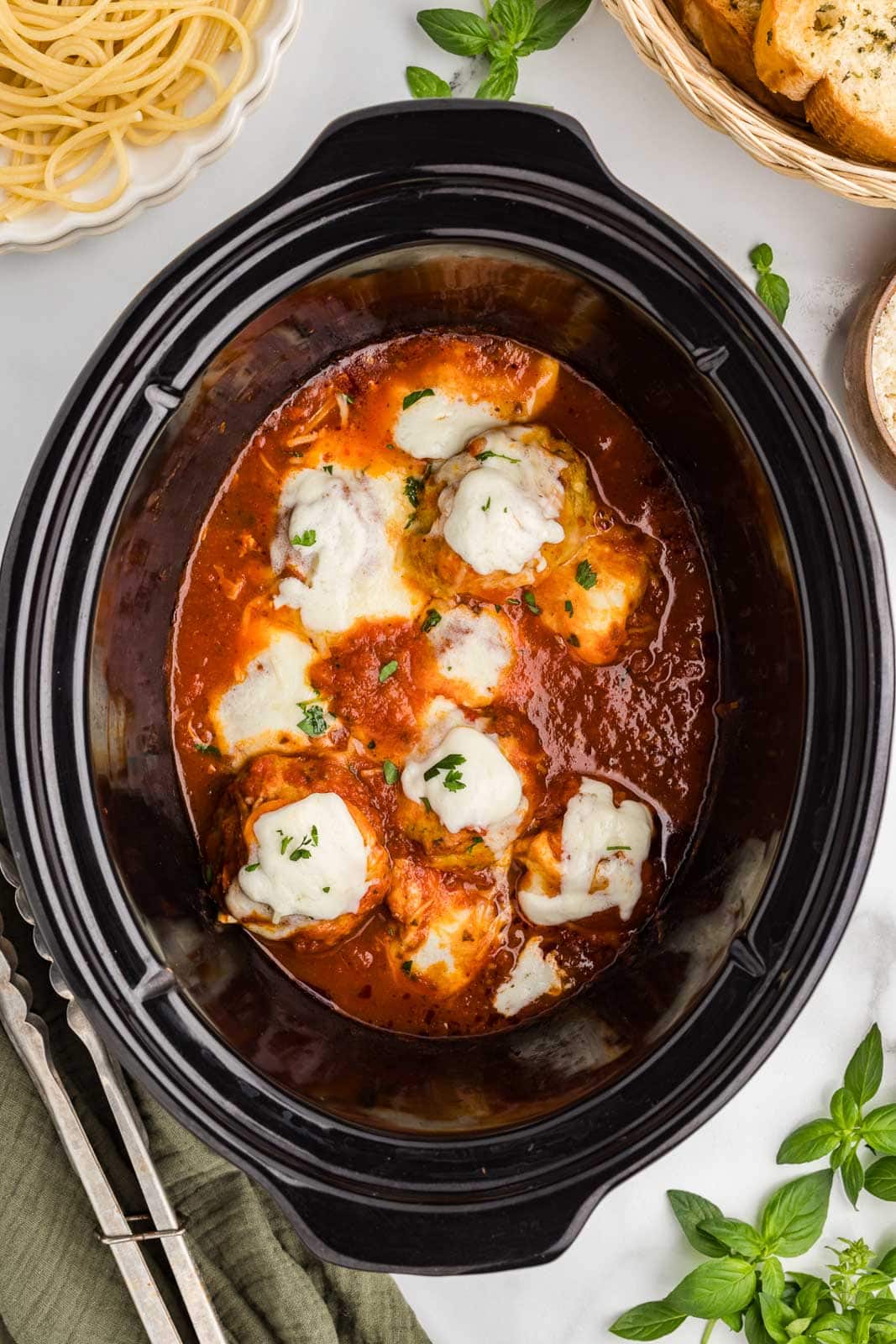 overhead view of black slow cooker with cooked meatballs