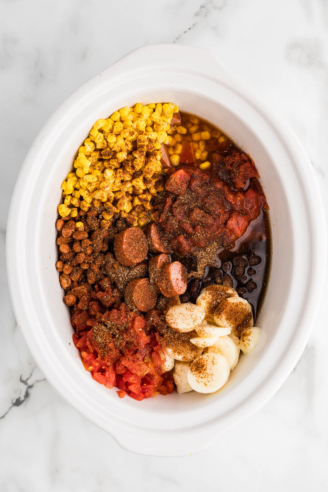 white slow cooker containing all ingredients