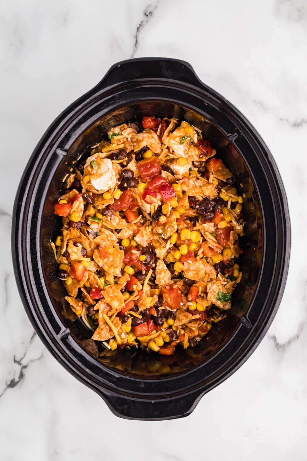 overhead view of black slow cooker containing all mixed ingredients