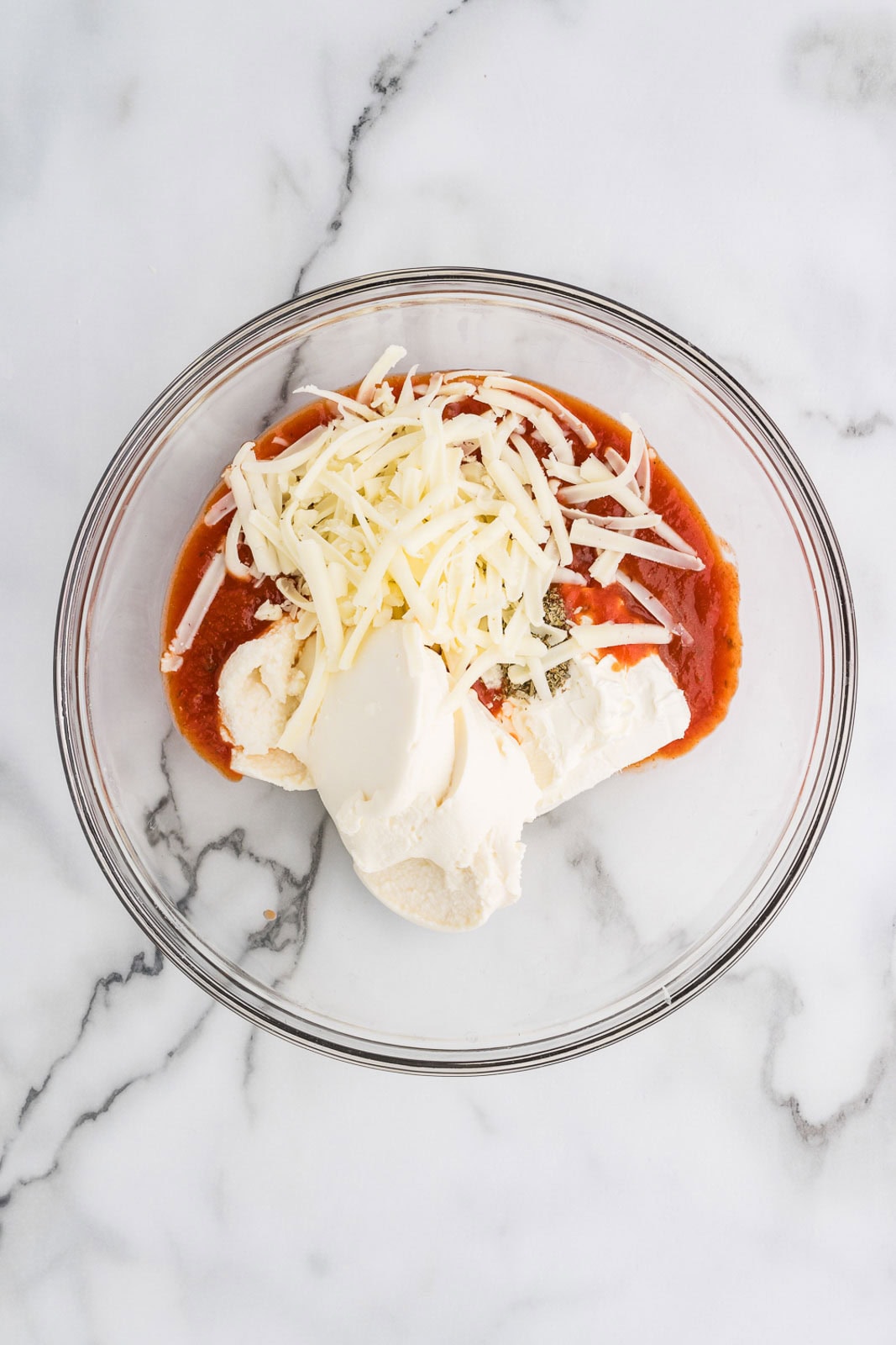 glass bowl of ricotta cheese, cream cheese, pizza sauce, Italian seasoning and mozzarella cheese