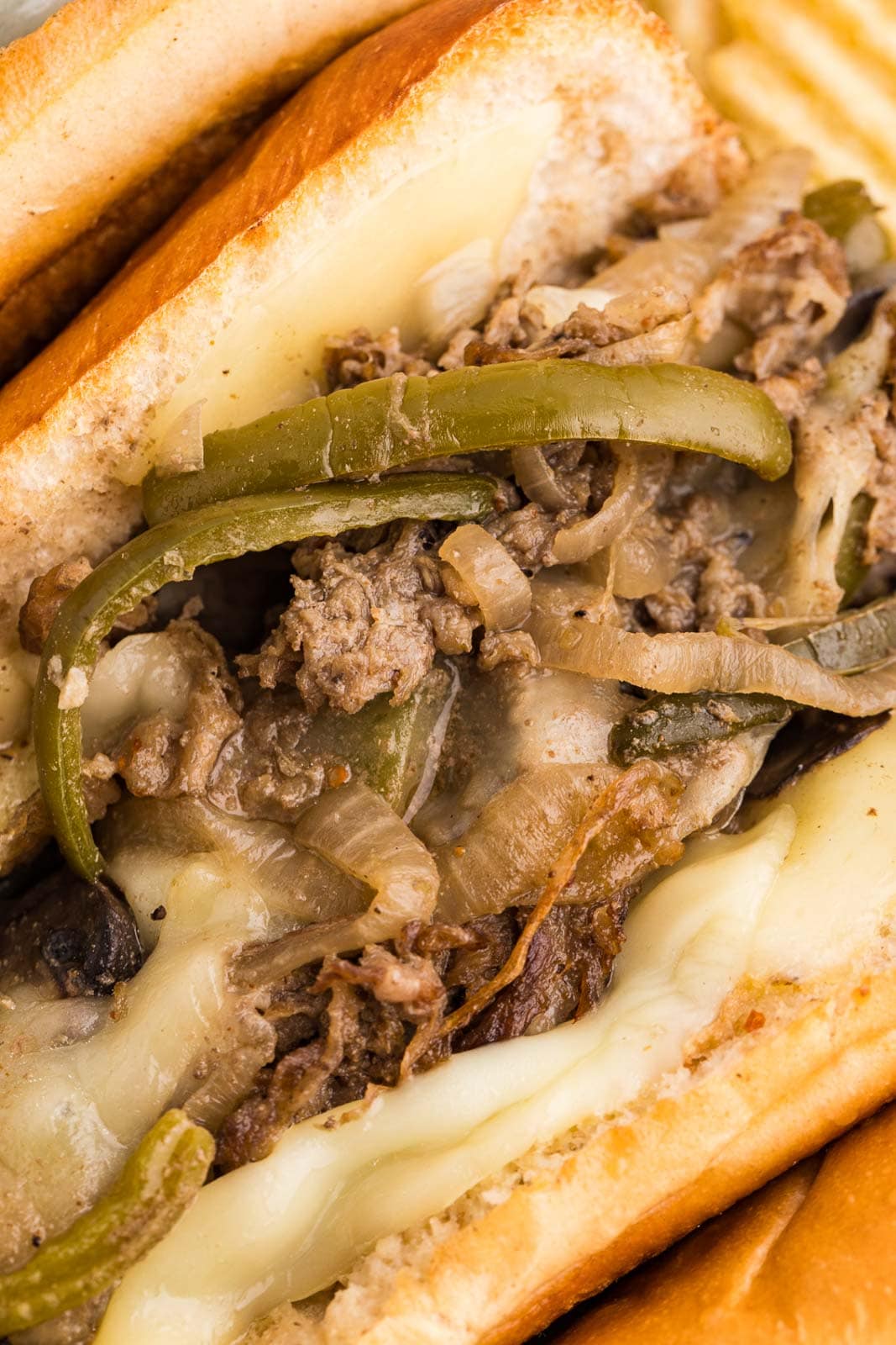 closeup of hoagie filled with beef steak mixture with melted cheese