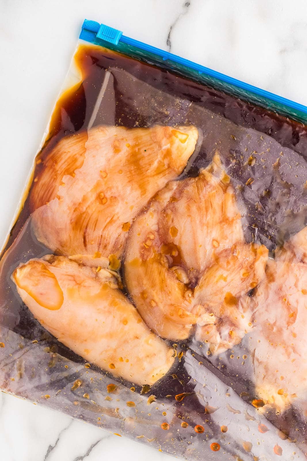 plastic bag containing chicken and marinade