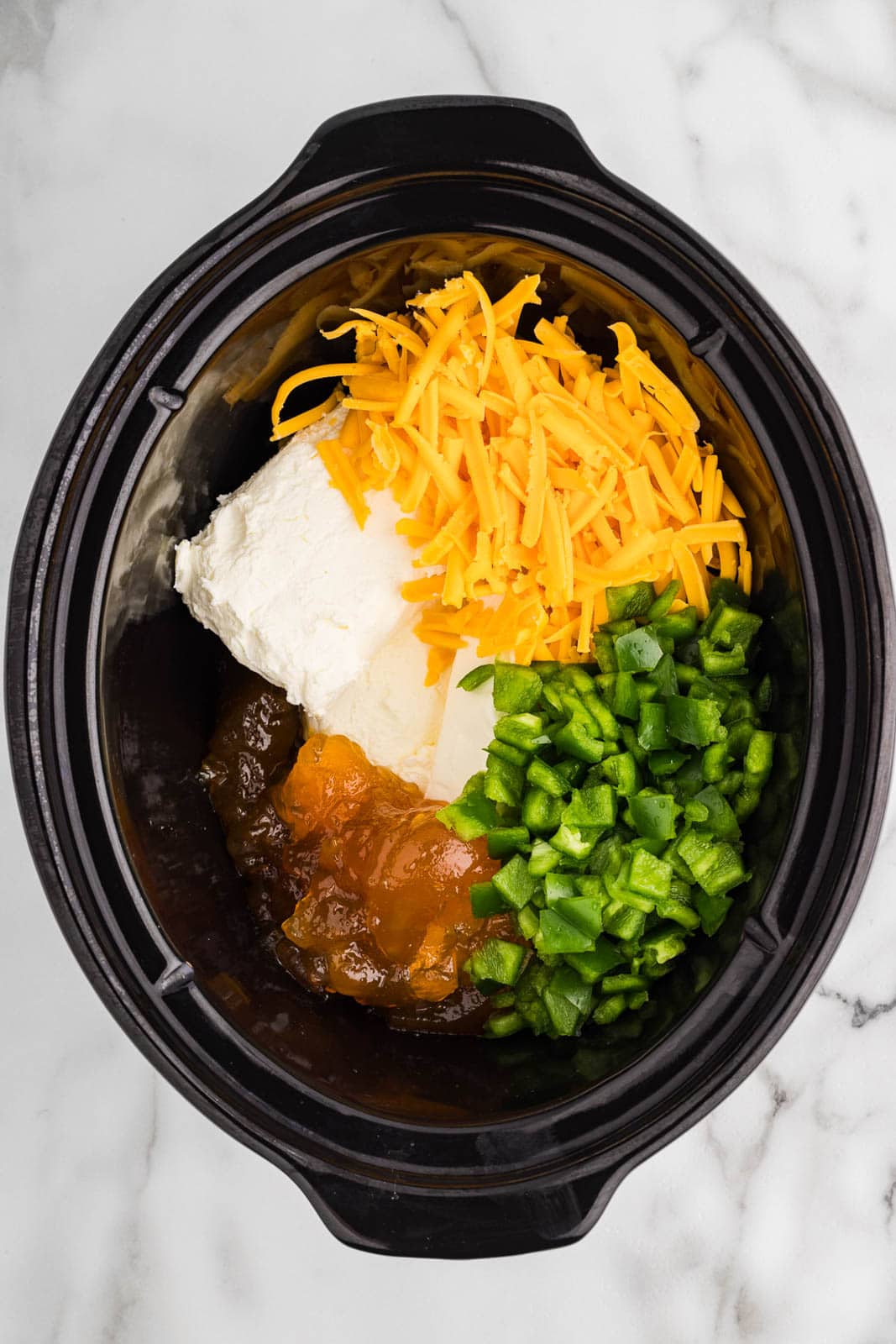 overhead view of black slow cooker with all ingredients