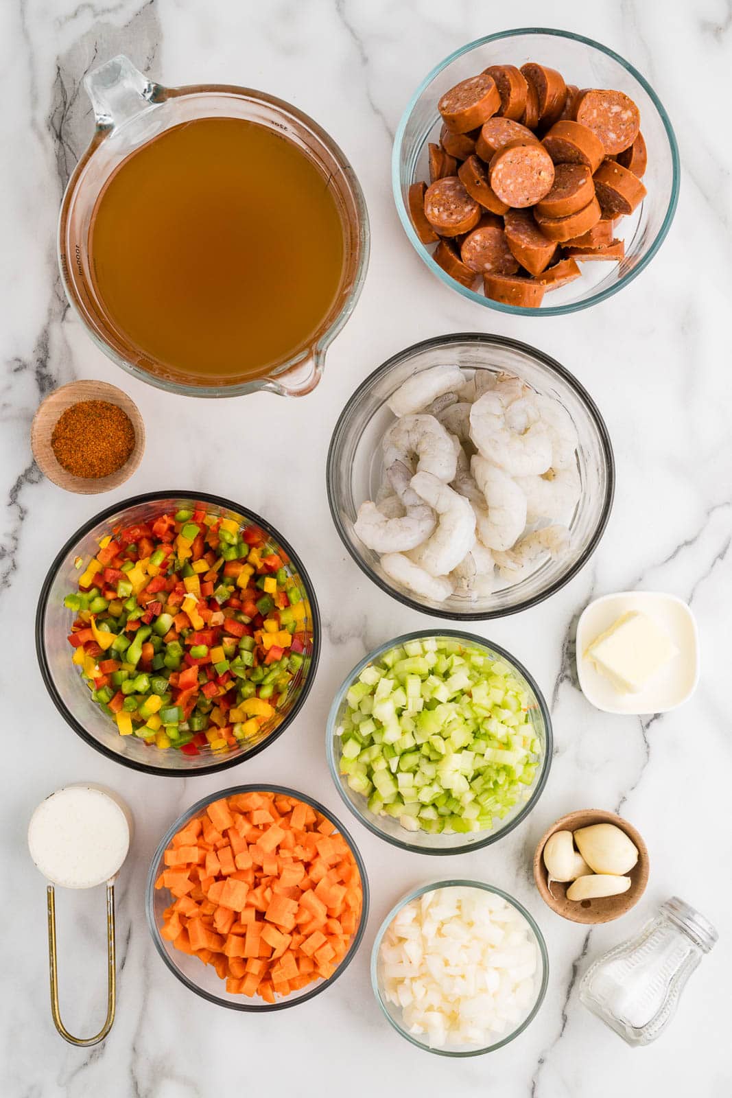 ingredients to include containers of sliced Andouille sausage, shrimp, diced celery, diced onions, diced carrots, diced peppers, vegetable broth, butter, garlic cloves, Cajun seasoning, salt, and cream