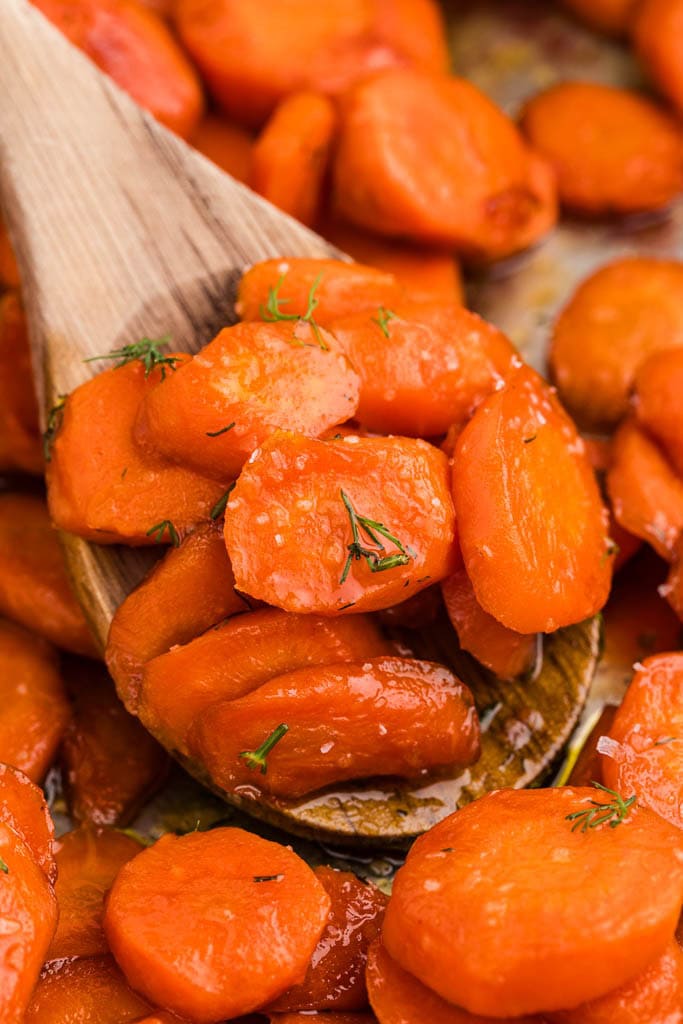 closeup of wooden spoon containing sauteed carrots