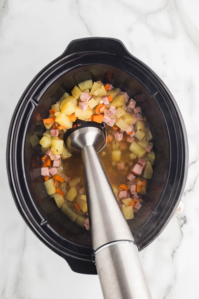 slow cooked ingredients with immersion blender inserted