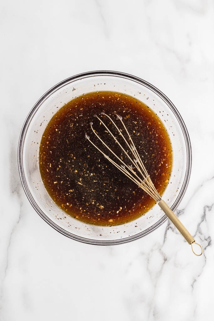 glass bowl with sauce ingredients with metal whisk